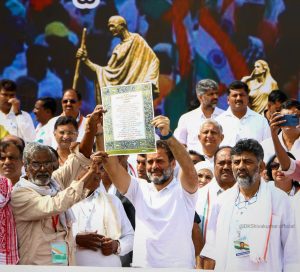 Renowned Dalit writer Devanoor Mahadev holds up a copy of the Preamble with Rahul Gandhi. (Twitter: IncKarnataka)